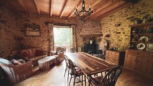 A rustic kitchen with a wooden table, chairs, and stone walls. - Stunning Dordogne Holiday House and private heated pool. (Saint-Pompont)