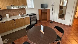 Una cocina moderna con armarios de madera, horno integrado y un comedor con una mesa redonda y cuatro sillas.