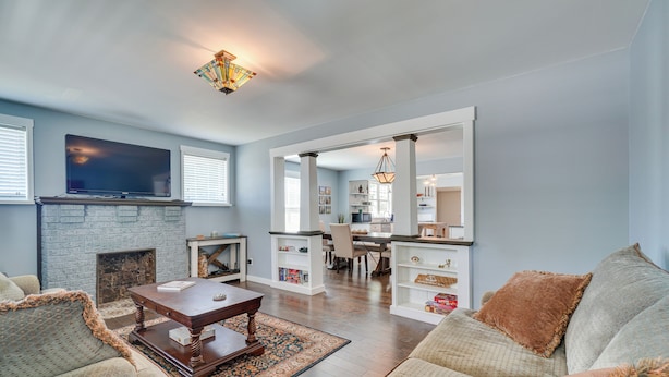A spacious living room with a fireplace, a dining area, and a kitchen visible through an open archway. - '1001 Sevier Bungalow': 2 Mi to Neyland Stadium! (Knoxville)