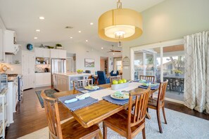 A spacious kitchen with wooden cabinets, a dining table set for four, and a large window overlooking a balcony. - Beautiful Marble Falls Getaway on Lake Lbj! (Marble Falls)