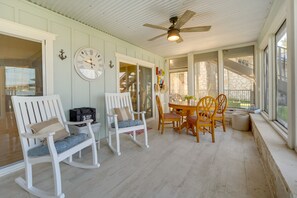 A covered porch with rocking chairs, a table, and chairs. There is a clock on the wall and a ceiling fan. - Beautiful Marble Falls Getaway on Lake Lbj! (Marble Falls)
