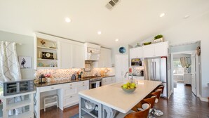 A modern kitchen with white cabinetry, a central island, and a long countertop. - Beautiful Marble Falls Getaway on Lake Lbj! (Marble Falls)