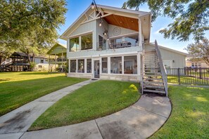 A two-story house with a large balcony, a staircase, and a well-maintained lawn. - Beautiful Marble Falls Getaway on Lake Lbj! (Marble Falls)