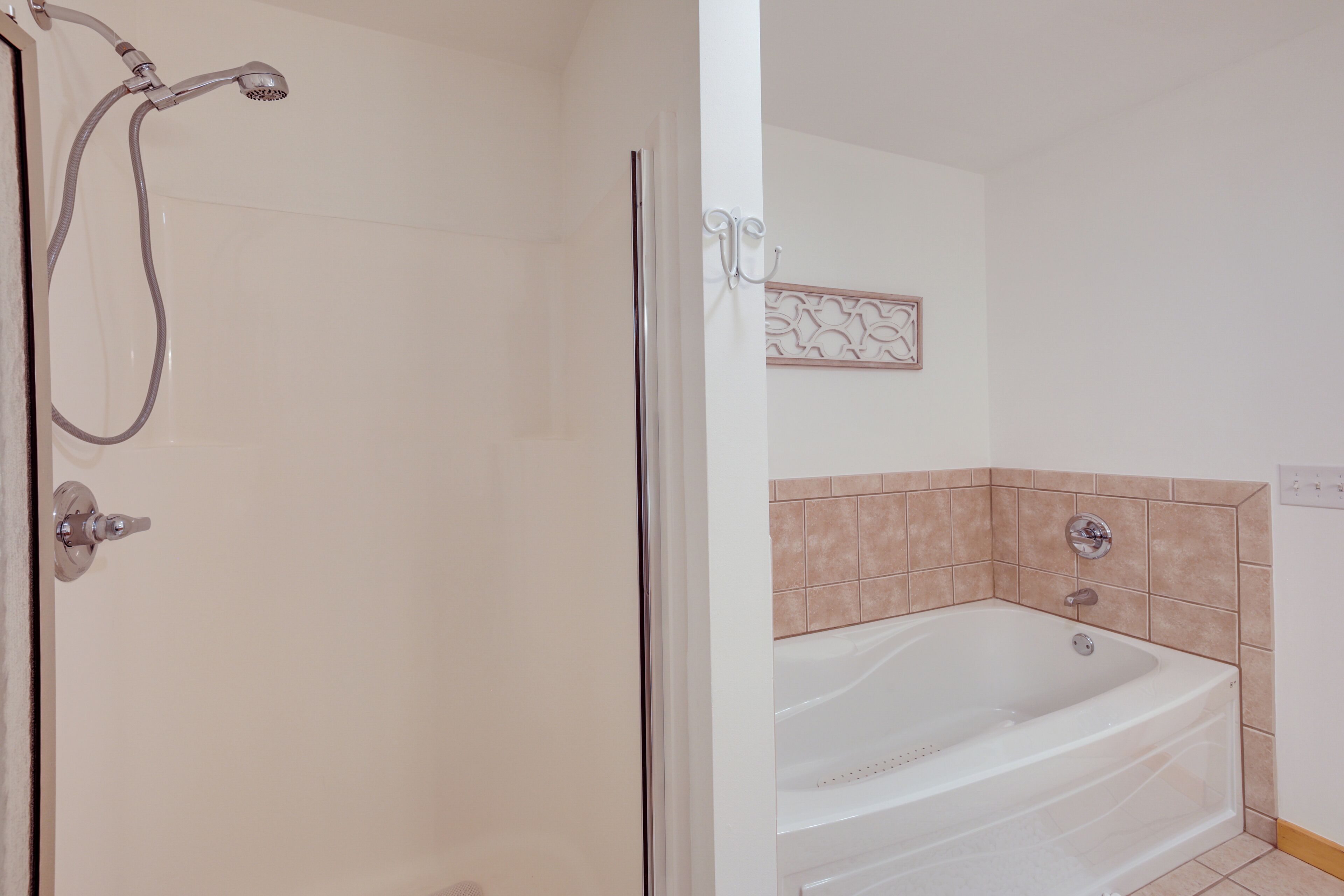 Une salle de bain équipée d’une douche, d’une baignoire et d’un porte-serviettes fixé au mur.