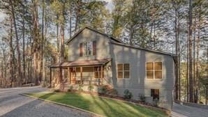 A two-story house with a porch, surrounded by a forest. - Mississippi Retreat w/ Hot Tub, Deck & Lake Views! (Terry)