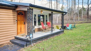 A log cabin with a porch, a wooden door, and two rocking chairs. - Fire Pit & Covered Deck! Cozy, Rustic Cosby Cabin (Cosby)