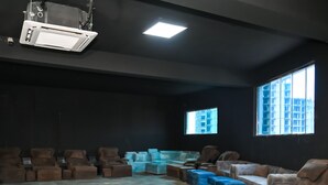 A spacious room with a high ceiling, a projector, and multiple windows. - HITE Resort Greater Noida (Greater Noida)