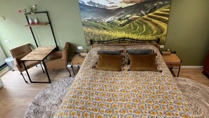 A bedroom with a bed, a desk, and a chair.