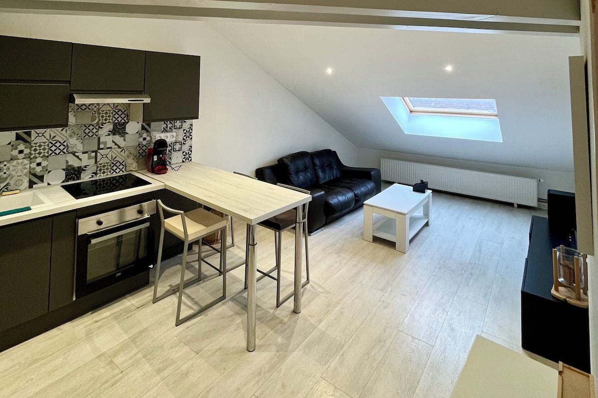 Moderni loft-tyylinen huoneisto, jossa on keittiö, ruokailutila ja oleskelutila.