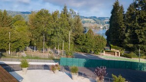 Vista de un campo deportivo con una pista verde y un área de asientos con macetas.