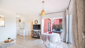 A bright living room with a dining area, a TV, and a view of the outside. - Spacious condo with Sea View, Walking distance to the Beach, Pool, Parking, Wifi (manilva)