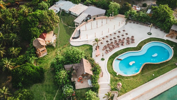 An aerial view of a resort with a swimming pool, beach, and a boat dock. - Anaho Beach Club (Cartagena)