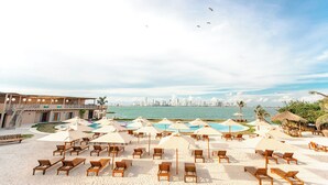 A beachside resort with sun loungers, umbrellas, and a swimming pool. - Anaho Beach Club (Cartagena)