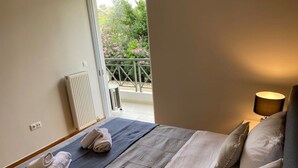 A bedroom with a bed, a radiator, a window, and a balcony with a railing. - Classy 3BR with 2 Bathrooms Apartment in Marousi (Athens)