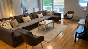 A modern living room with a sectional sofa, a coffee table, and a TV stand. - Classy 3BR with 2 Bathrooms Apartment in Marousi (Athens)