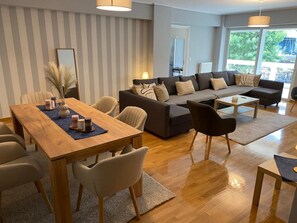 Uma sala de estar moderna com uma mesa de jantar de madeira, um sofá e uma mesa de centro.