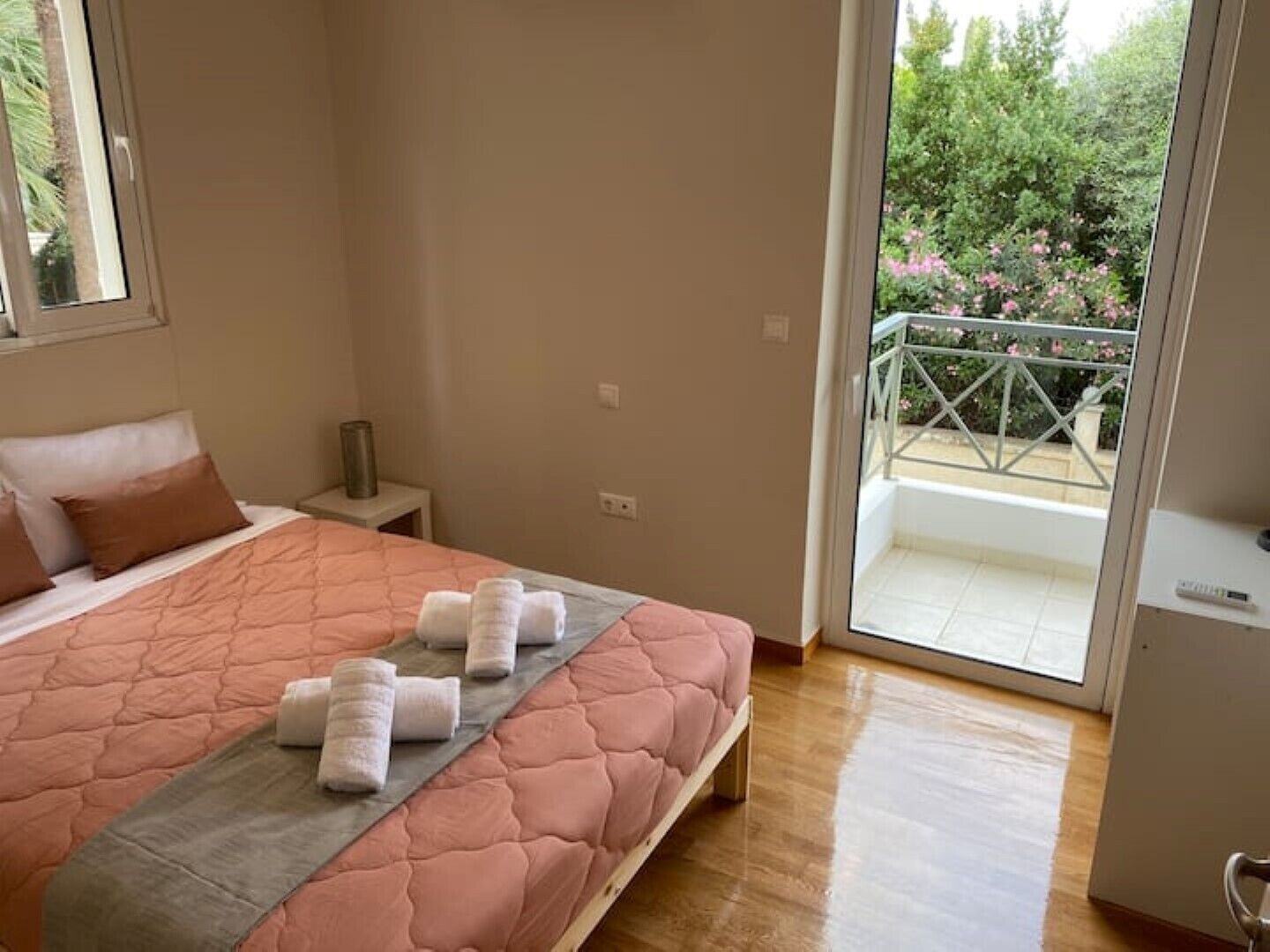Une chambre à coucher avec un lit, une table de chevet, une fenêtre et un balcon.