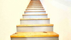 Eine Treppe mit Holzbodenstufen und grauen Trittflächen.