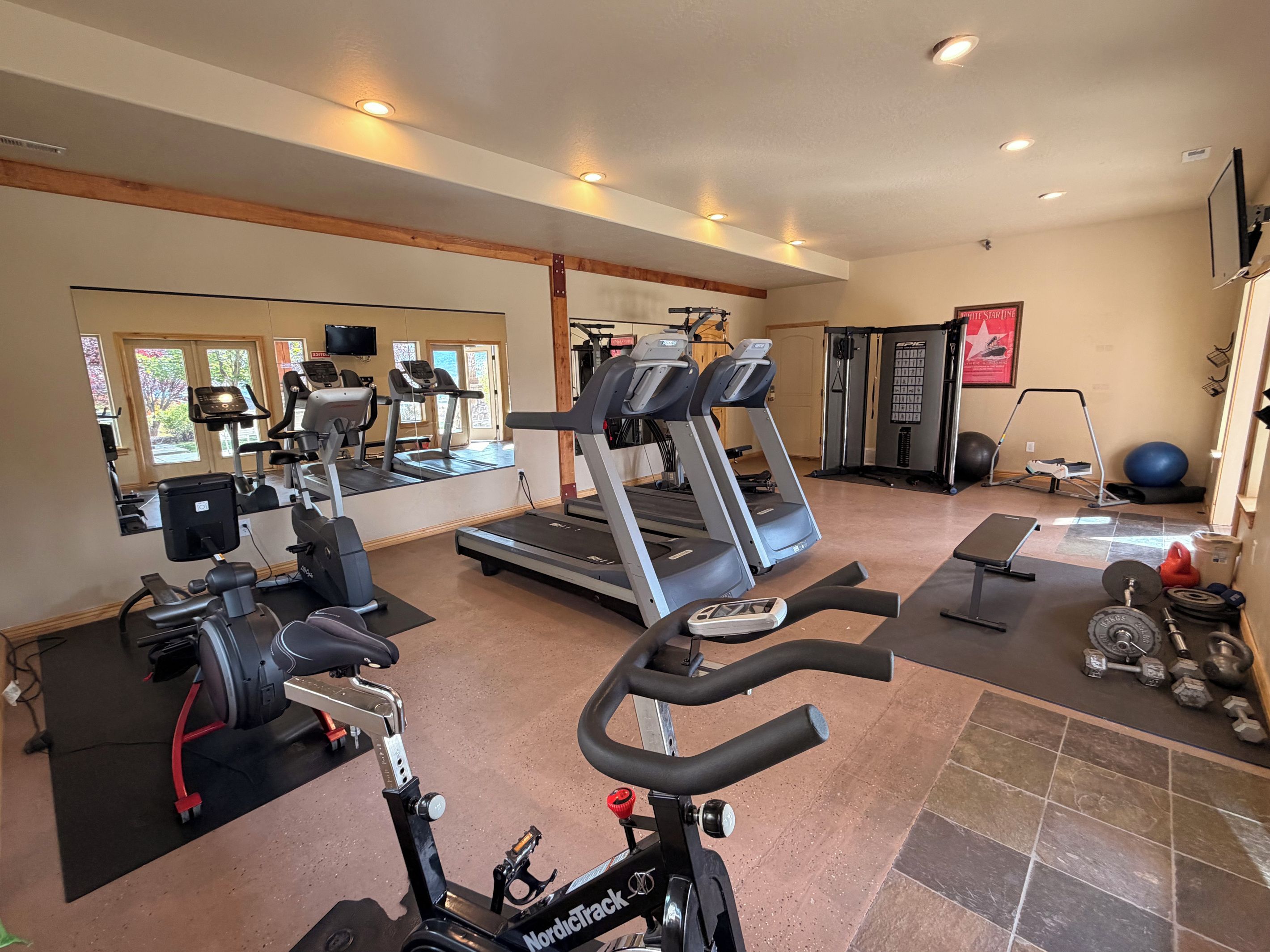 A gym with treadmills, exercise bikes, and weight equipment.