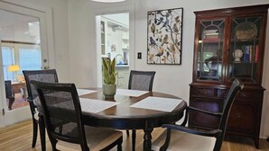 A dining area with a round wooden table, four chairs, and a potted plant. - Porch Swing Place - Newly Renovated Charm
 (Springfield)