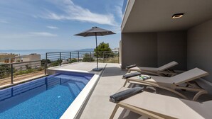 A rooftop pool area with a view of the sea, lounge chairs, and an umbrella. - Villa VIP with heaed swimming pool and 4 Bedrooms, Several terraces with seaview (Makarska)