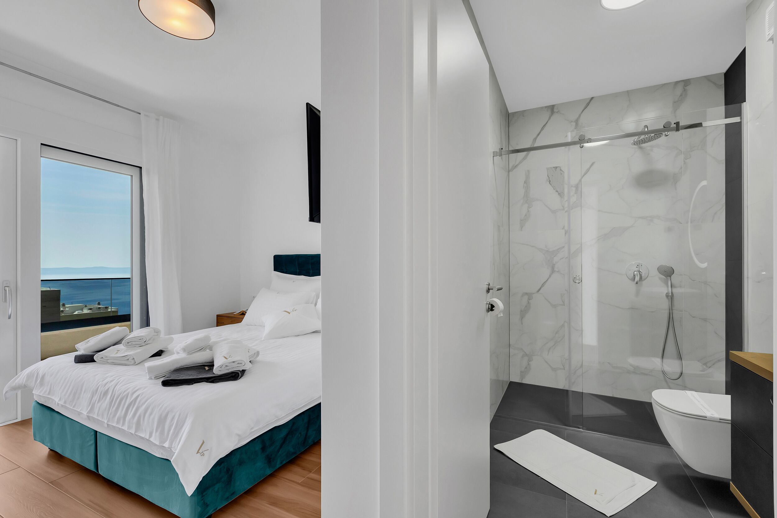 Et moderne hotelværelse med seng, badeværelse med bruser og havudsigt.