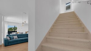 A modern interior with a staircase, a blue sofa, and a dining area. - Villa VIP with heaed swimming pool and 4 Bedrooms, Several terraces with seaview (Makarska)