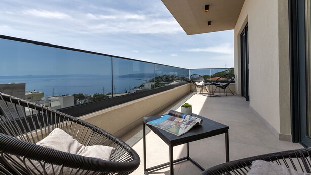 A balcony with wicker chairs, a small table with a magazine, and a view of the sea. - Villa VIP with heaed swimming pool and 4 Bedrooms, Several terraces with seaview (Makarska)