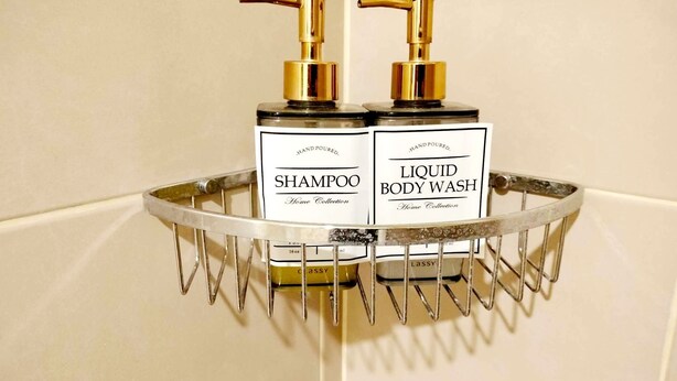 Een badkamerschaar met twee flessen handgiet shampoo en douchegel.
