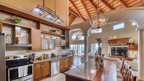 A spacious kitchen with wooden cabinets, stainless steel appliances, and a large island.