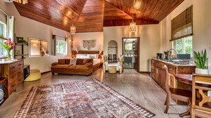 A spacious living area with a large rug, wooden ceiling, and a cozy seating area.