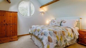 A bedroom with a bed, a wardrobe, a window, and a wall-mounted light fixture. - Charming 2-bed Cottage, Beautiful Views, Knutsford (Knutsford)