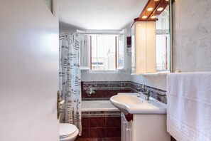 A bathroom with a bathtub, sink, and toilet.