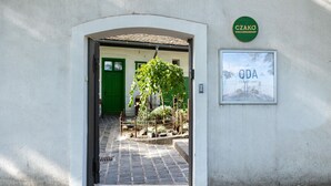 A doorway leading to a courtyard with a hanging plant, a green door, and a sign for 'Czako Bed & Breakfast'. - Czakó Bed & Breakfast (Budapest)