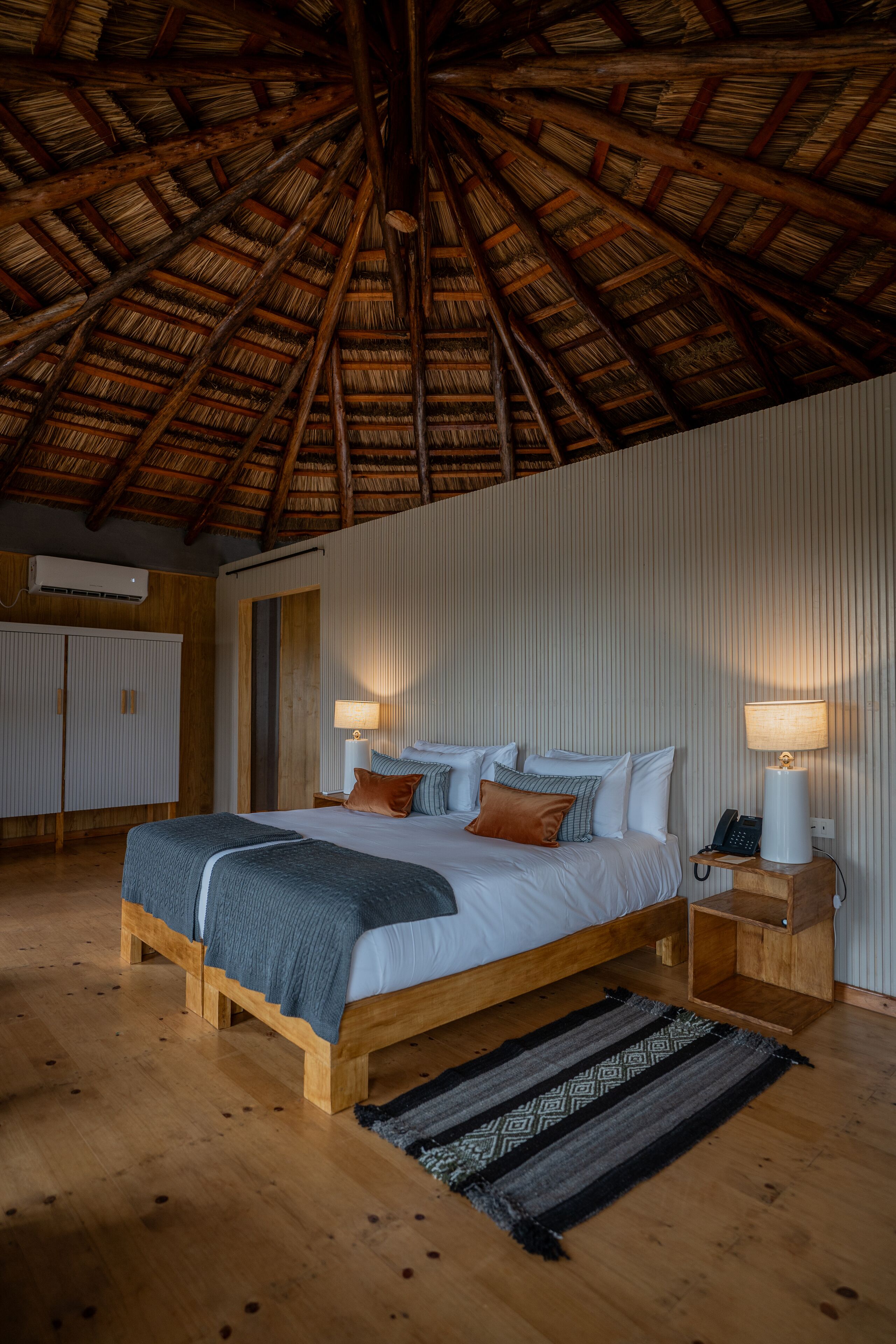 A bedroom with a wooden bed, a nightstand, a lamp, and a wardrobe.