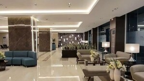 Een moderne lobby met een gepolijste marmeren vloer, eigentijdse meubels en sfeervolle verlichting.