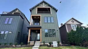 A two-story house with a front porch, a visible staircase, and a 'Coming Soon' sign. - New Build Hot Tub Dtown ShortNorth (Columbus)