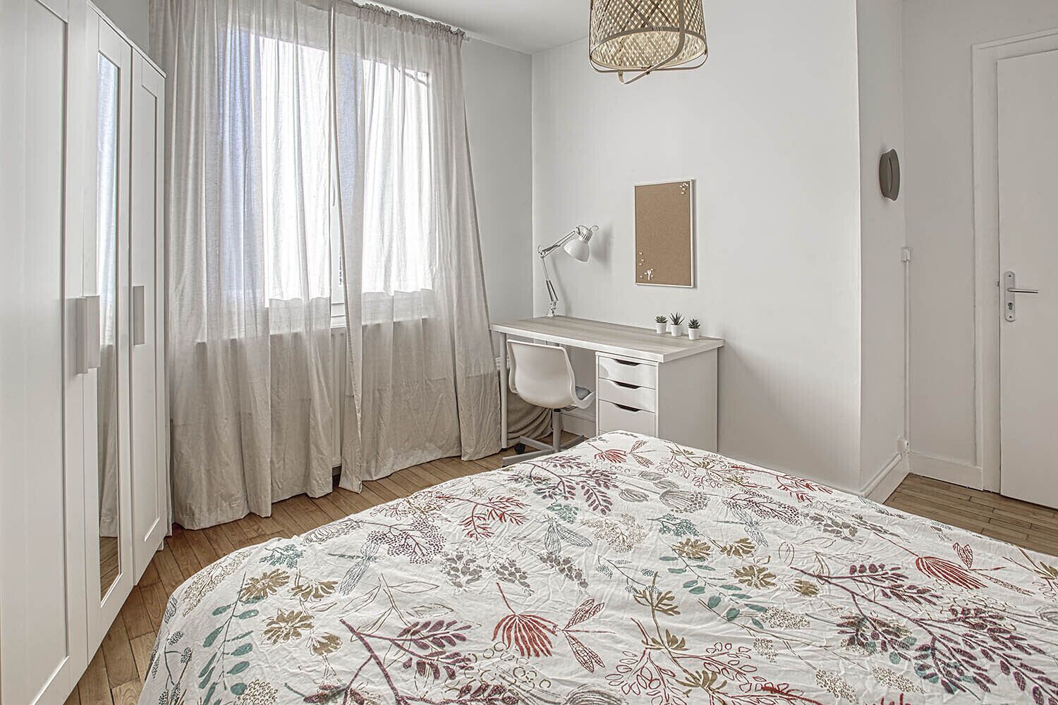 A bedroom with a bed, a desk, and a chair.