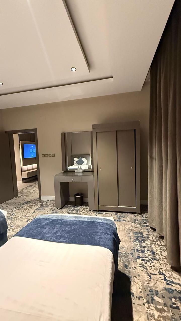 Una camera d'albergo con un letto, una scrivania, un armadio e un televisore.
