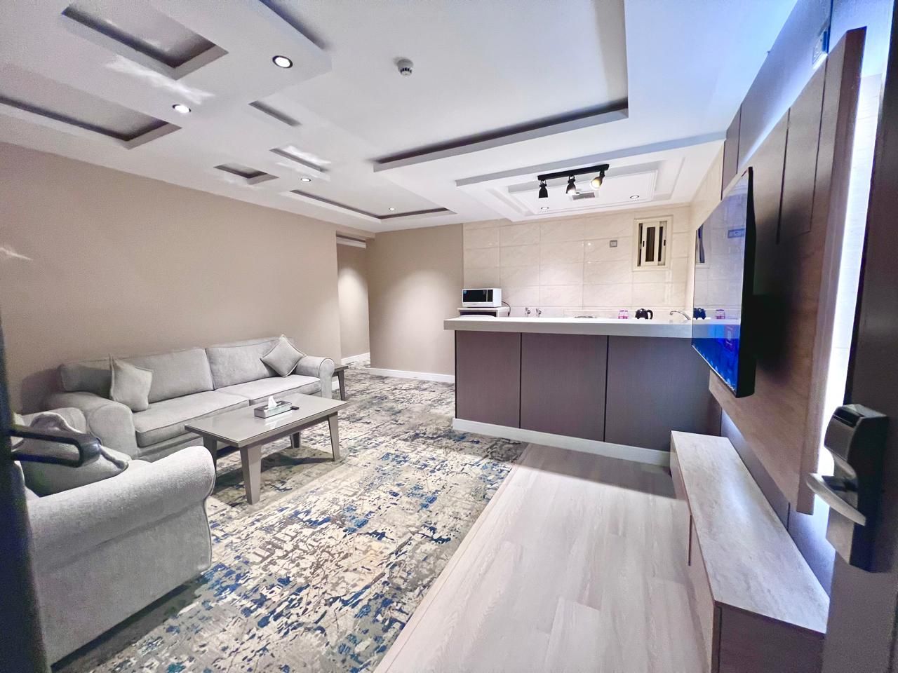 Una sala de estar moderna con un sofá, una mesa de centro y un televisor montado en la pared.