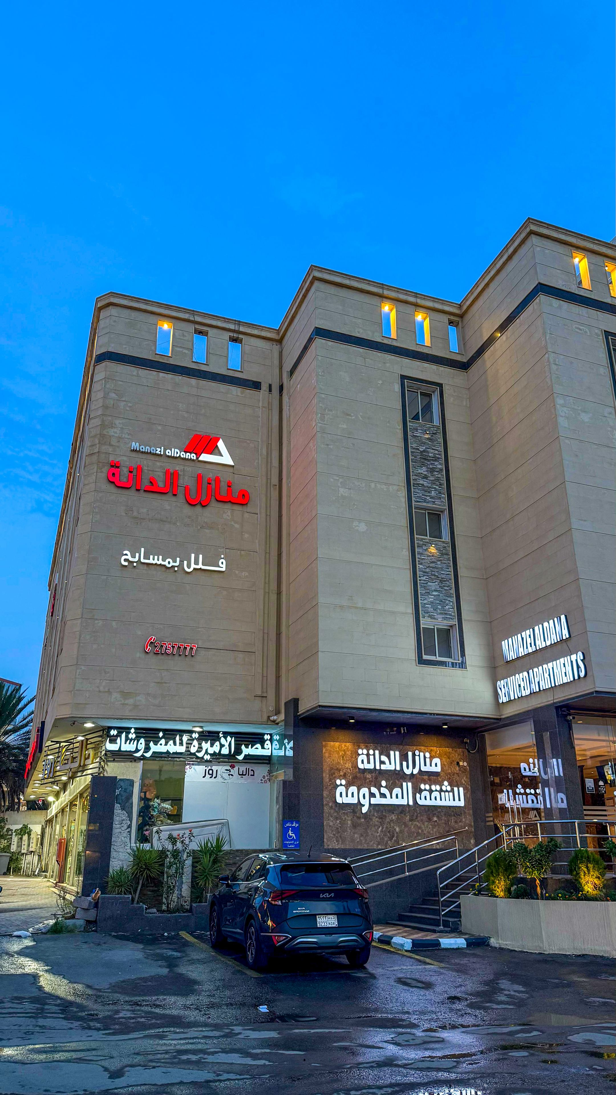 A multi-story building with signage for 'Manzel Aldana' and 'Serviced Apartments'.