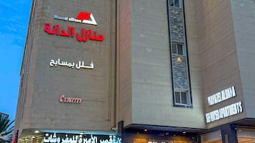 A multi-story building with signage for 'Manzel Aldana' and 'Serviced Apartments'.