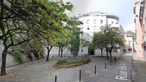 A street with trees, a white building, and a sign reading "Rue des Ht".