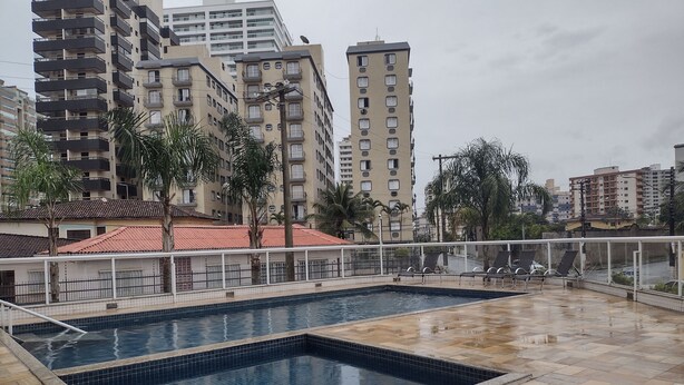 A rooftop swimming pool with tiled flooring and lounge chairs. - Rua Maria Tognini 296 (Praia Grande)