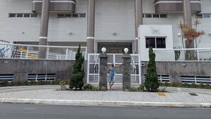 A multi-story building with balconies, a gated entrance, and a parking area. - Rua Maria Tognini 296 (Praia Grande)