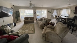 A spacious living room with a large sofa set, a coffee table, and a dining area with a table and chairs. - Eagle Dunes gated community. Minutes from Orlando, Disney and Daytona Beach!  (Sorrento)