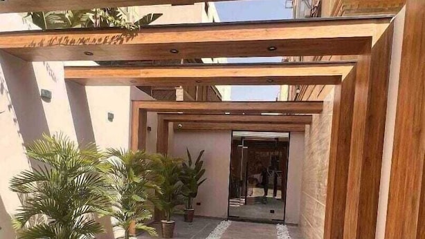 Un passadís cobert amb plantes en testos que condueix a l'entrada d'un edifici.