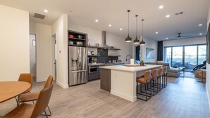 A modern kitchen with a central island, stainless steel appliances, and pendant lighting. - Residence 3: The Villas At Troon North (Scottsdale)