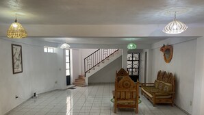 A spacious room with a tiled floor, a staircase, two wooden beds, and hanging lamps. - Casa Mila Taxco, pueblo mágico, ubicada en Centro Histórico, cerca de todo a pie (Taxco)