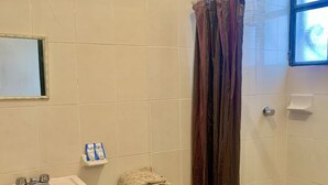 A bathroom with a sink, toilet, and shower curtain. - Casa Mila Taxco, pueblo mágico, ubicada en Centro Histórico, cerca de todo a pie (Taxco)